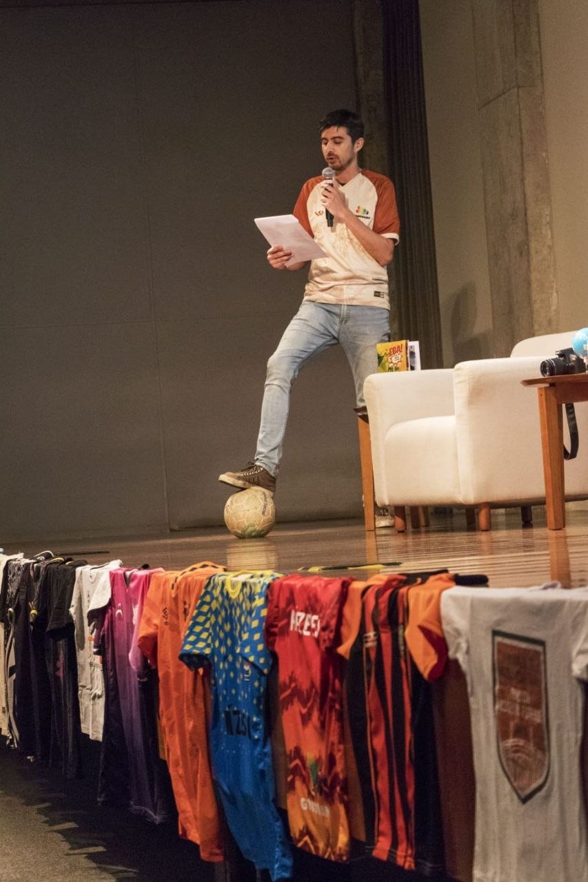 Palestra com bola no pé e arquivo de camisas de futebol